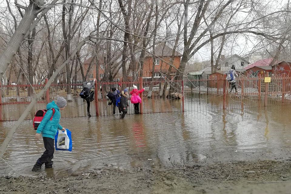 Лужа у новосибирской школы для ребят стала своего рода игрой. Фото: Инна Новосельцева