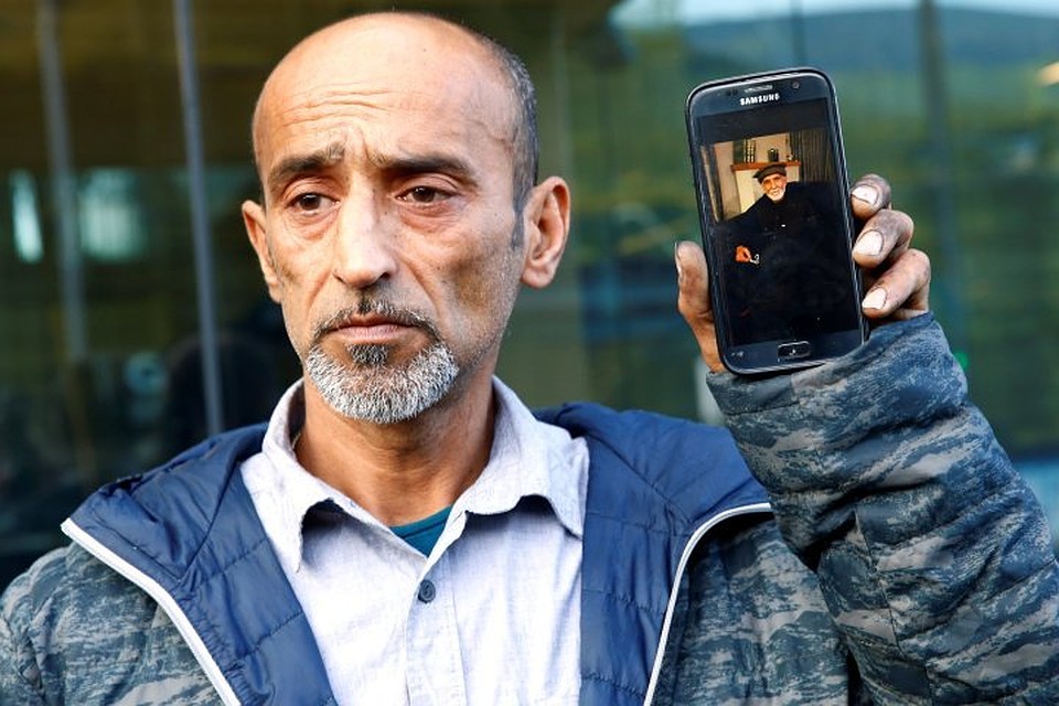 Омар Наби показывает журналистам фотографию отца