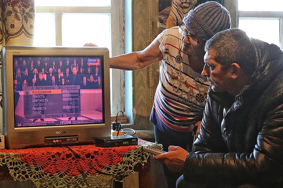 Волонтер помогает жительнице одного из сел Рыбновского района Рязанской области подключить новое оборудование для приема цифрового телевидения, февраль 2019 г. Фото: Александр Рюмин/ТАСС