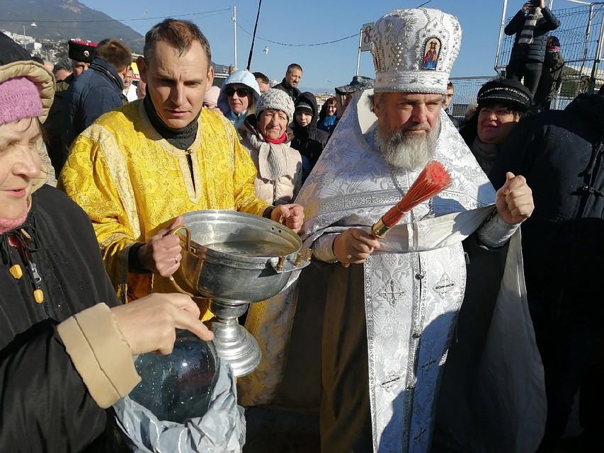 Отец Адам окропляет всех крещенской водой
