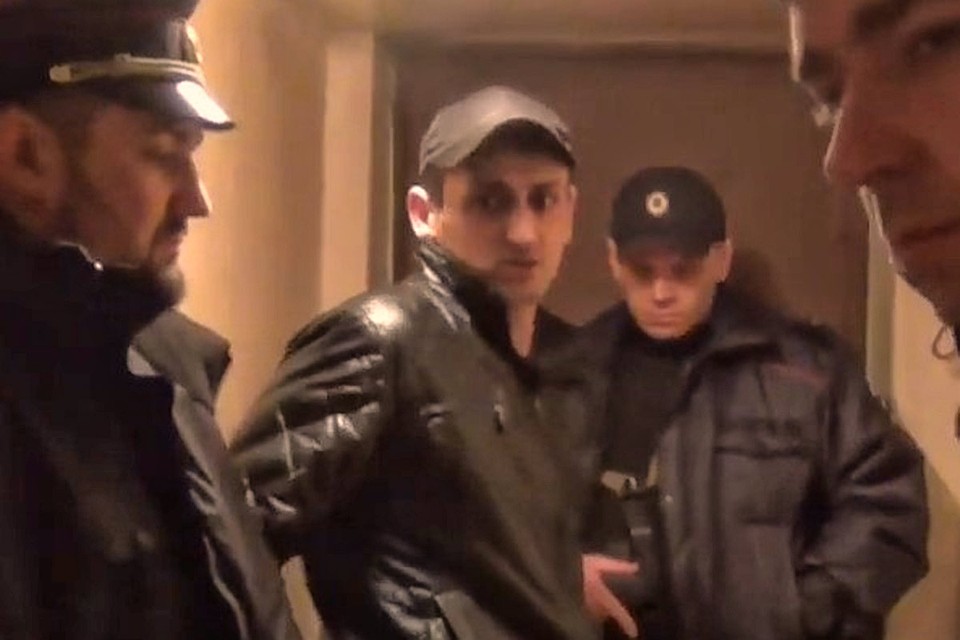 Один из обвиняемых (в центре) во время следственного эксперимента.