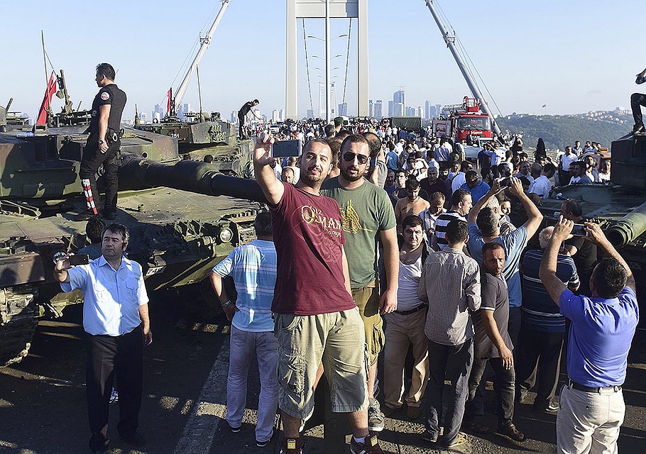 Жители Стамбула фотографируются у моста через Босфорский пролив, оставленного военными. Фото: REUTERS