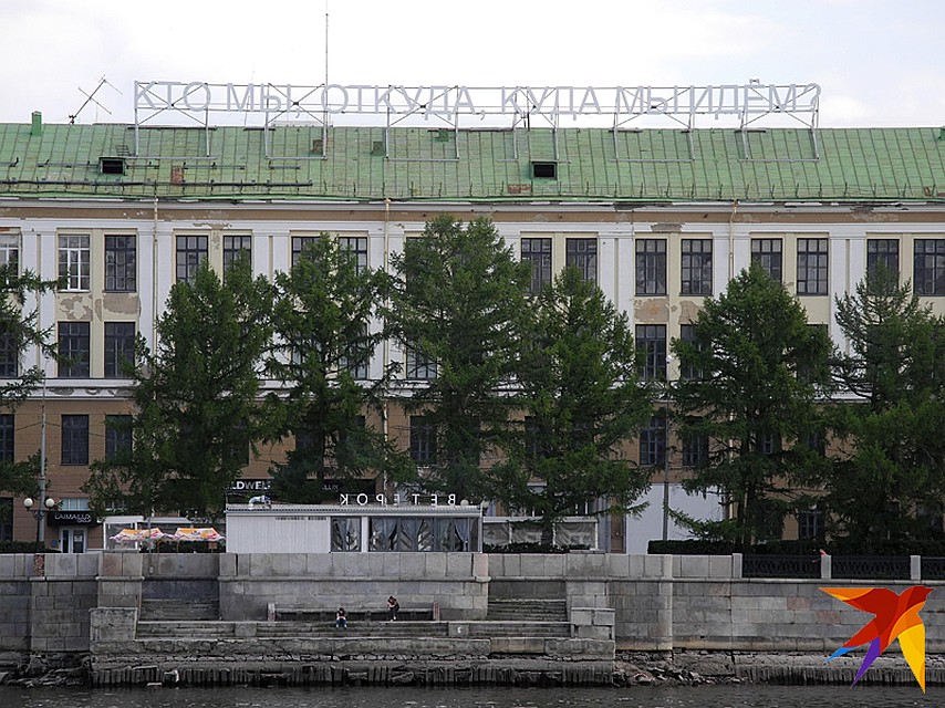 На доме на другом берегу Исети написано: «Кто мы, откуда, куда мы идём?». Фото: Ульяна СКОЙБЕДА