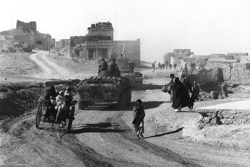 Танковая бригада советских войск и местных беженцев на дороге разрушенного села в Кандагарской области. Фото: EAST NEWS