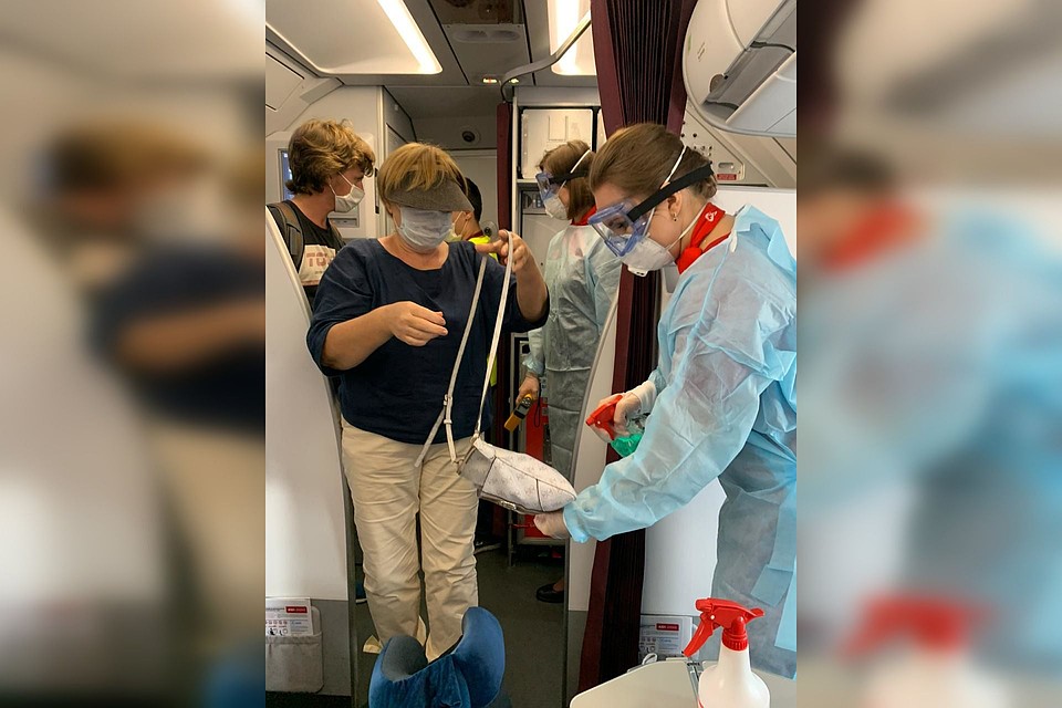 В Бангкоке при посадке пассажиров на борт стюардессы обрабатывали ручную кладь и руки пассажиров, а сами были в респираторах, перчатках, очках и в защитных костюмах. Фото: предоставлено пресс-службой авиакомпании «Уральские авиалинии»