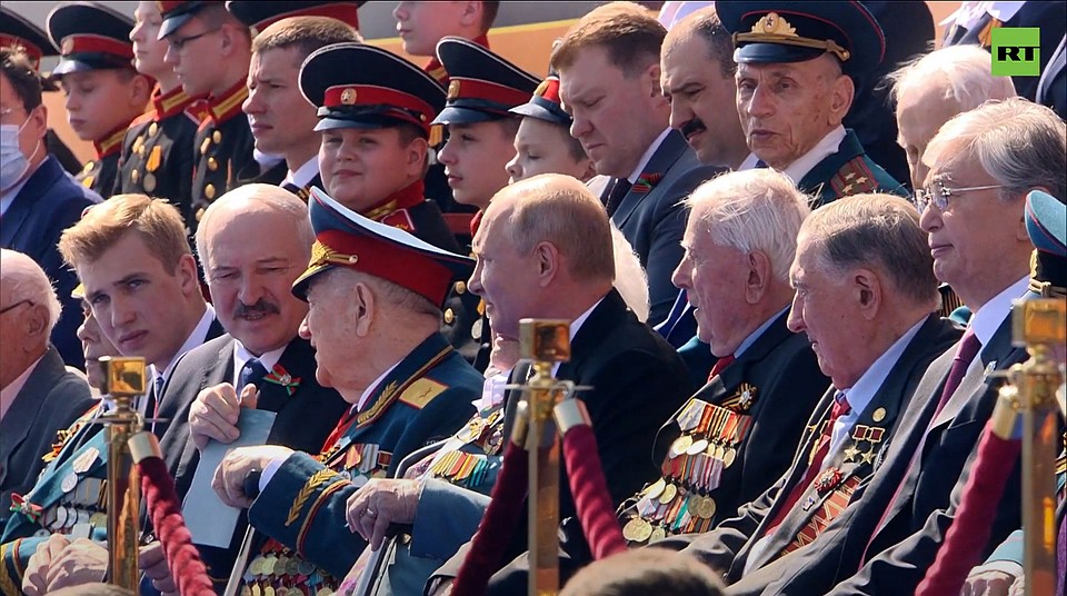 На VIP-трибуне Лукашенко сидел между своим младшим сыном и ветераном. Старшие сыновья президента Беларуси сидели в следующем ряду. Кадр телетрансляции.