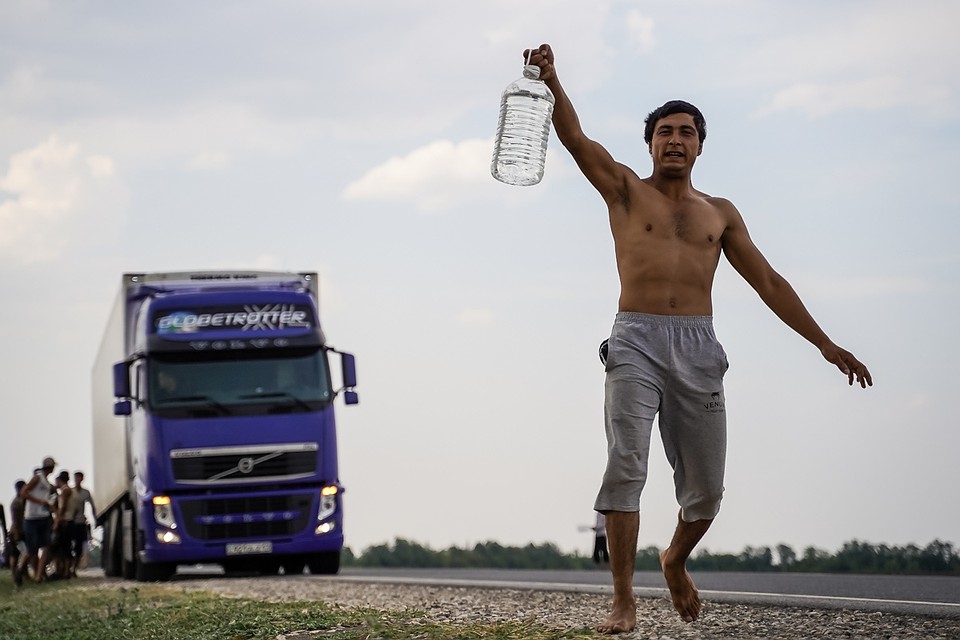 На трассе многочисленные мигранты тормозят фуры, чтобы водители поделились водой Фото: Светлана МАКОВЕЕВА