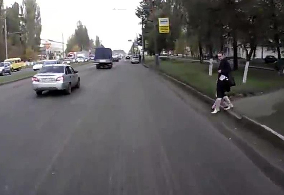Женщина с девочкой собираются переходить дорогу.