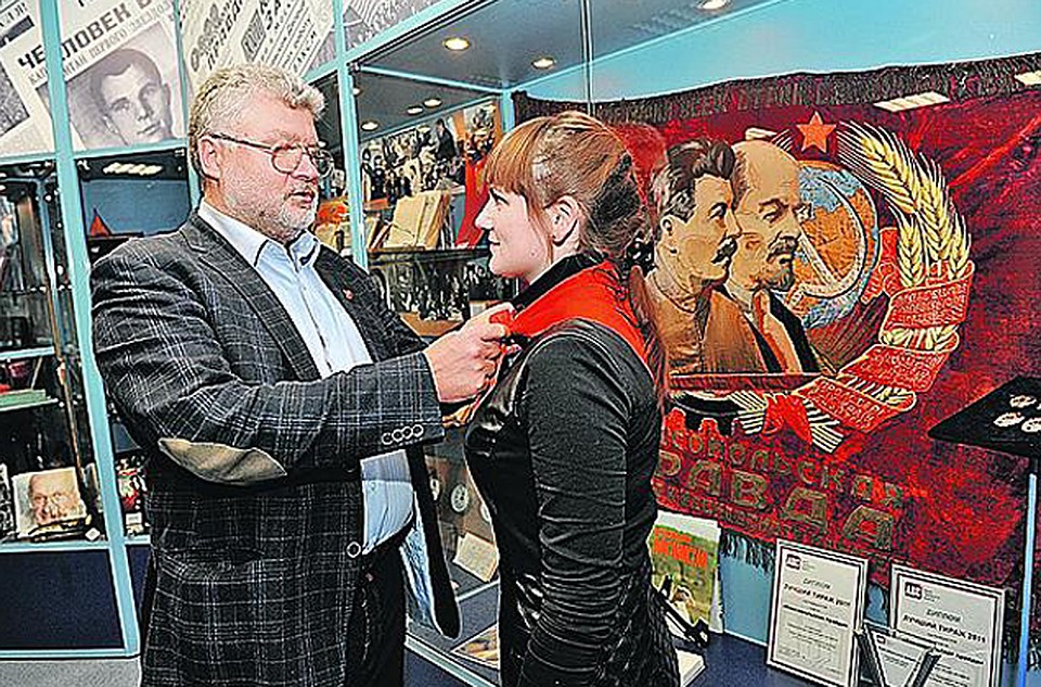 После записи на ТВ «КП» Юрий Поляков (с комсомольским значком!) заглянул в наш редакционный музей и показал юному стажеру отдела политики Ангелине Галаниной, как правильно повязывать пионерский галстук. (Справа на снимке - легендарное знамя «Комсомольской Фото: Евгения ГУСЕВА