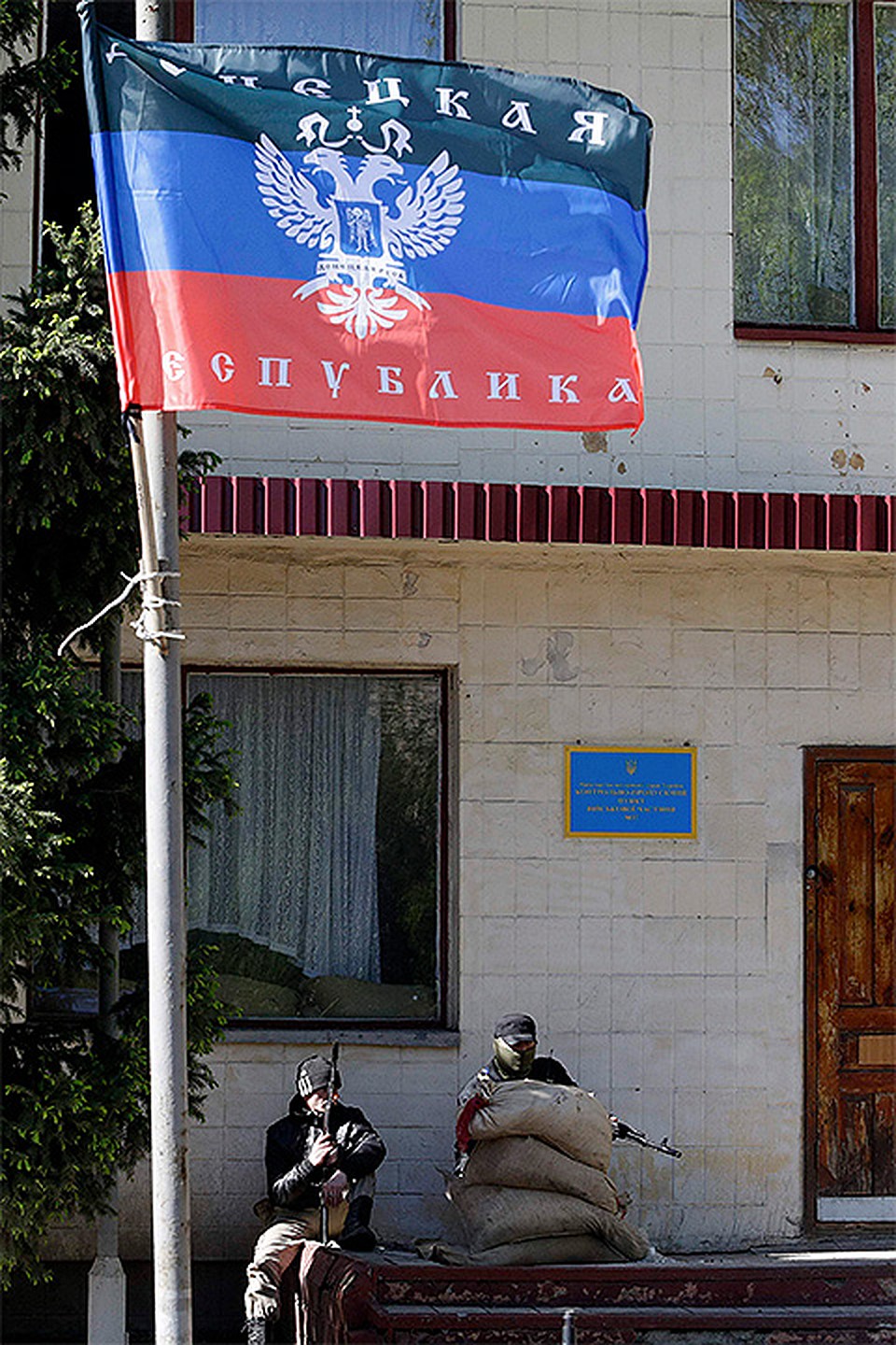 Вооруженные сторонники Донбасской народной республики у входа в административное здание в центре столицы региона Фото: REUTERS
