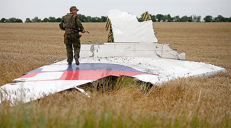 17 июля 2014 г., боец ДНР осматривает обломки рухнувшего Боинга. Фото: REUTERS