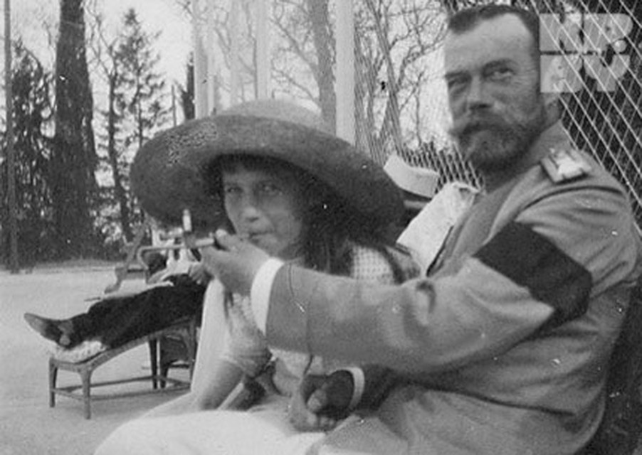 Николай II с дочерью в садах Могилева, шутя, позирует перед фотографом, предлагая наследнице покурить.