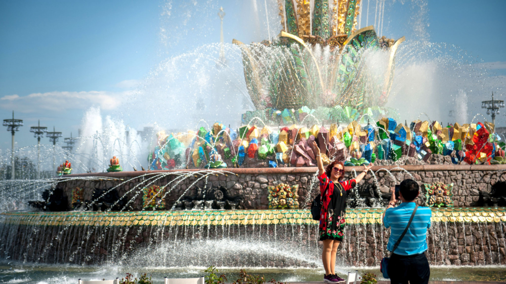 женщина фотографируется на фоне фонтана на вднх