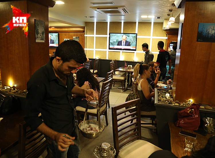 В районе Маззе, в одном из кафе, перед большими экранами полно народу.