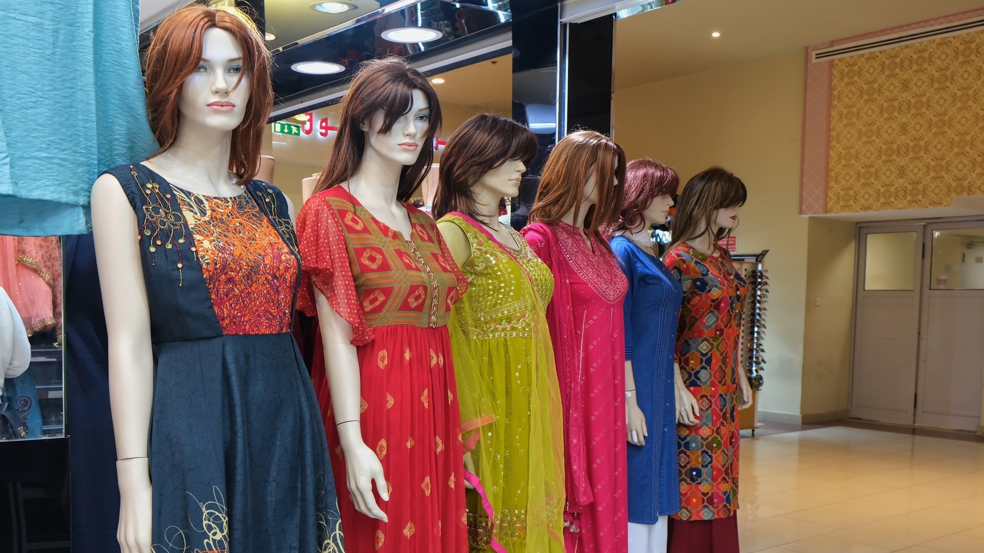 Манекены в ярких платьях на восточном рынке.