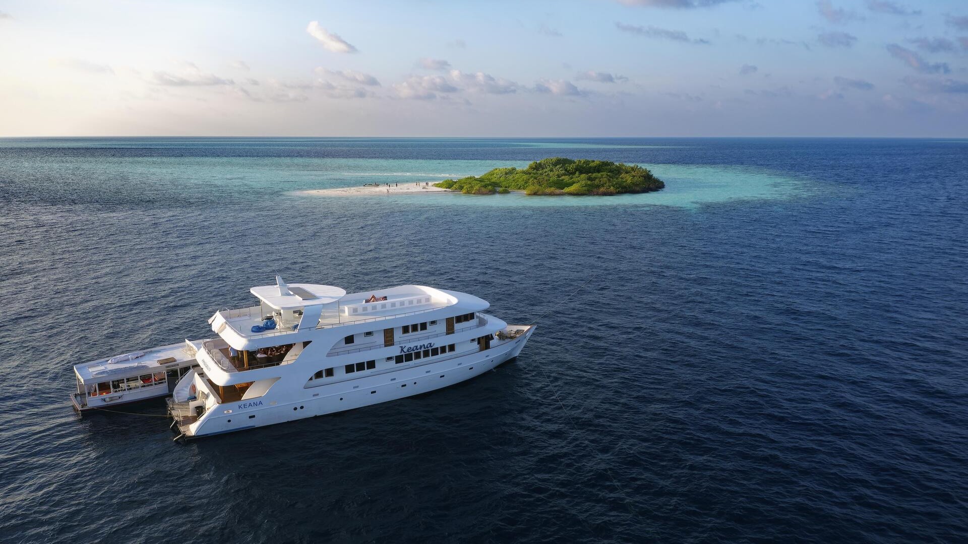 Сафари-катер с дайверской лодкой дхони у необитаемого острова, Мальдивы.