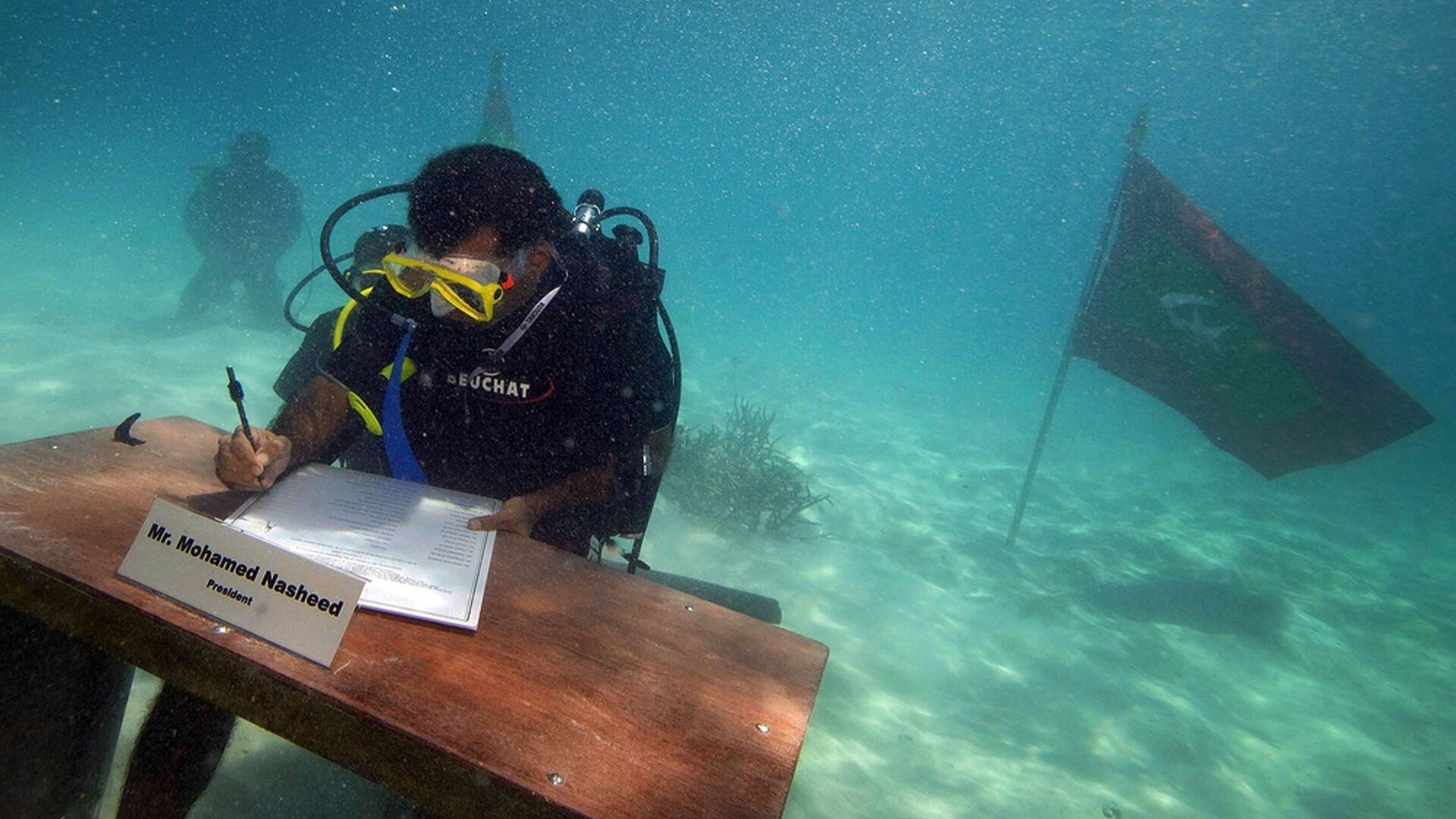 Президент Мохамед Нашед подписывает декларацию под водой на острове Гирифуши.
